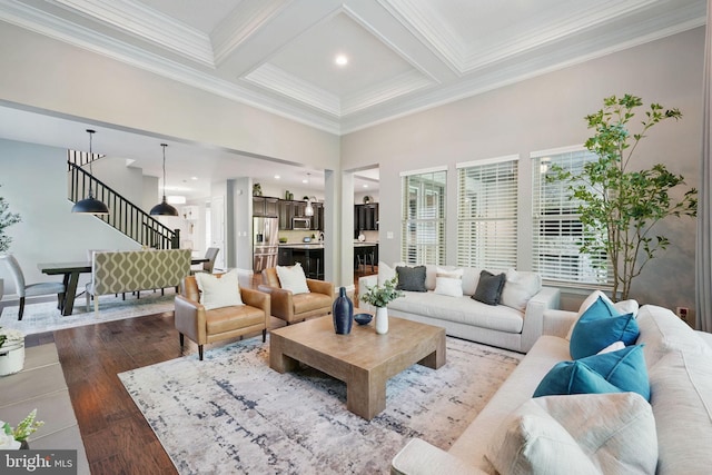 living room featuring stairway, beam ceiling, hardwood / wood-style flooring, coffered ceiling, and crown molding