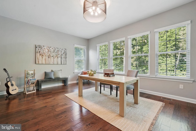 dining room featuring a chandelier, baseboards, and wood finished floors