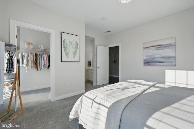 carpeted bedroom featuring a spacious closet, baseboards, a closet, and connected bathroom