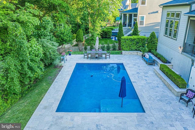 view of swimming pool featuring a patio area and fence