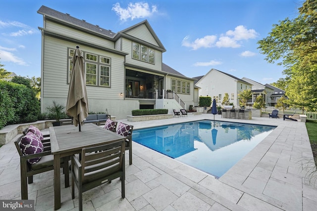 outdoor pool featuring a patio area, outdoor dining area, and stairs