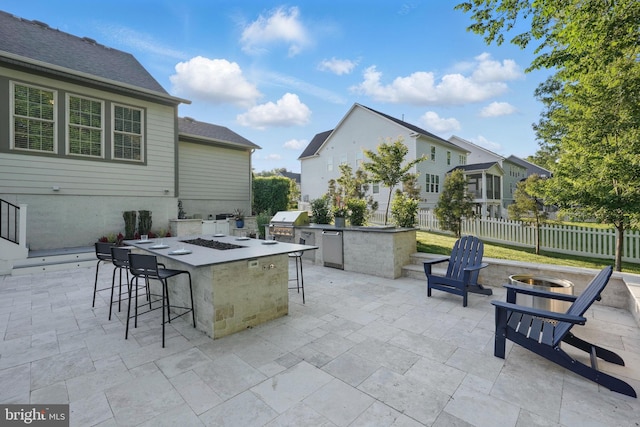 view of patio / terrace with an outdoor fire pit, area for grilling, grilling area, and fence