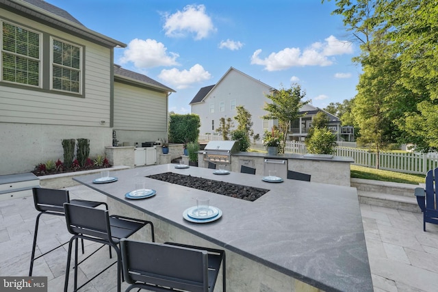 view of patio featuring an outdoor kitchen, area for grilling, fence, and outdoor dining space