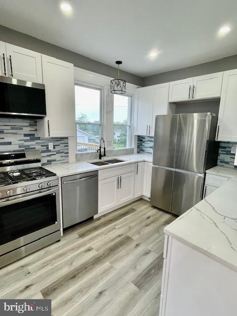 25 Elmont Ave, Baltimore, MD 21206 - kitchen featuring appliances with stainless steel finishes, a sink, tasteful backsplash, white cabinetry, and recessed lighting