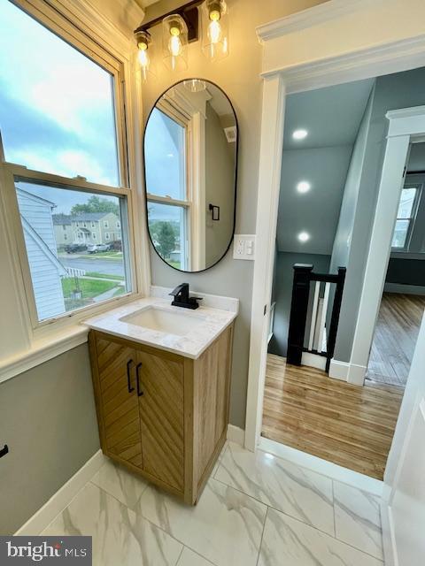 25 Elmont Ave, Baltimore, MD 21206 - bathroom featuring marble look tile flooring, baseboards, and vanity