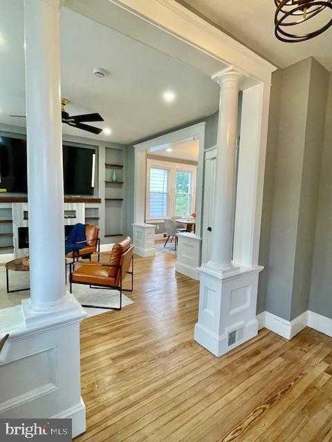 25 Elmont Ave, Baltimore, MD 21206 - living room featuring decorative columns, light wood-style floors, built in features, and baseboards