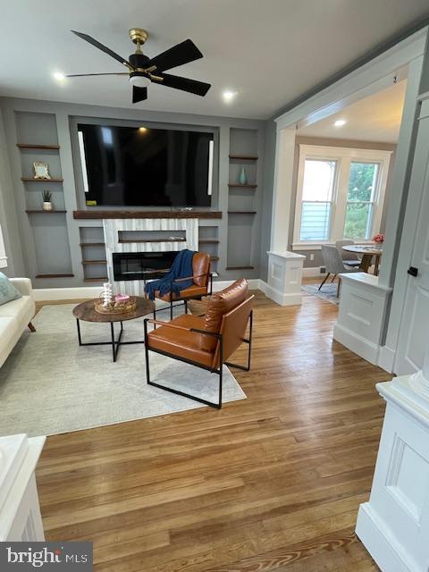 25 Elmont Ave, Baltimore, MD 21206 - living room with built in shelves, a fireplace, wood finished floors, and a ceiling fan