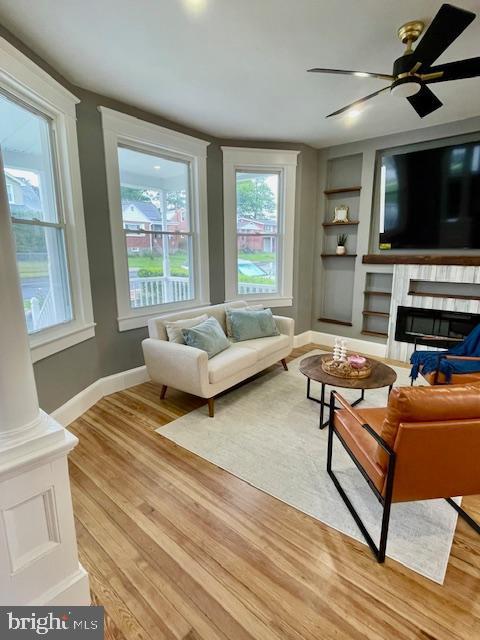 25 Elmont Ave, Baltimore, MD 21206 - living room featuring built in shelves, baseboards, healthy amount of natural light, and a glass covered fireplace