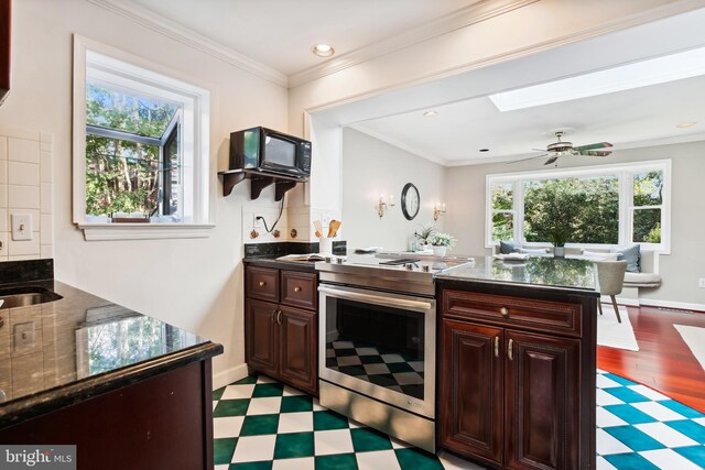 3122 1st St N, Arlington, VA 22201 - kitchen with stainless steel electric range oven, light floors, a peninsula, ceiling fan, and dark brown cabinetry