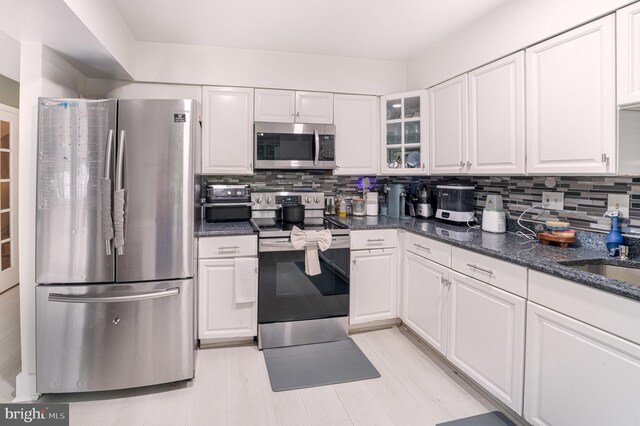 15210 Emory Ct, Bowie, MD 20716 - kitchen featuring stainless steel appliances, white cabinetry, decorative backsplash, glass insert cabinets, and dark stone countertops