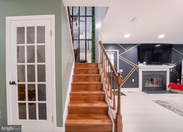 15210 Emory Ct, Bowie, MD 20716 - stairway featuring baseboards, a fireplace with flush hearth, wood finished floors, and recessed lighting