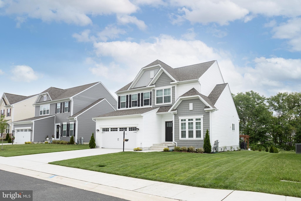 view of front of property featuring concrete driveway, a front yard, a shingled roof, and a garage