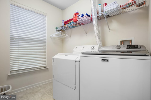 clothes washing area with baseboards and independent washer and dryer
