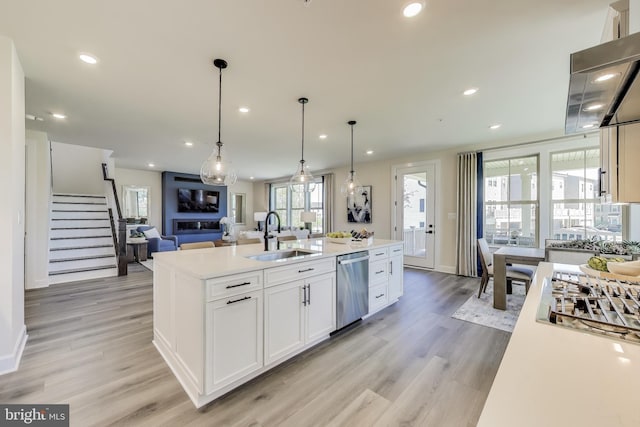 6501 Clubhouse Dr, Laurel, MD 20708 - kitchen featuring a sink, stainless steel appliances, light wood-style floors, white cabinets, and a center island with sink