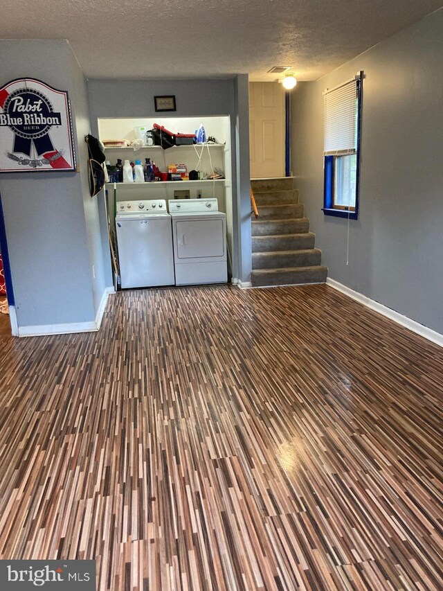189 Columbia Dr, Kearneysville, WV 25430 - unfurnished living room with wood finished floors, washer and dryer, baseboards, stairway, and a textured ceiling