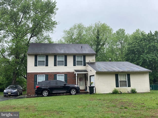 view of front facade with a front yard and brick siding
