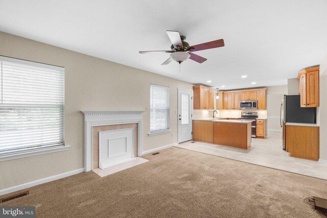 7481 Windswept Ct, Sykesville, MD 21784 - kitchen featuring appliances with stainless steel finishes, a ceiling fan, light countertops, a peninsula, and light colored carpet