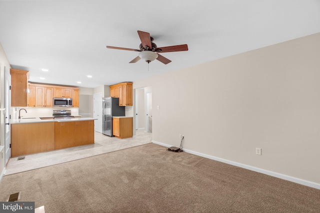7481 Windswept Ct, Sykesville, MD 21784 - kitchen featuring appliances with stainless steel finishes, light colored carpet, ceiling fan, open floor plan, and light countertops