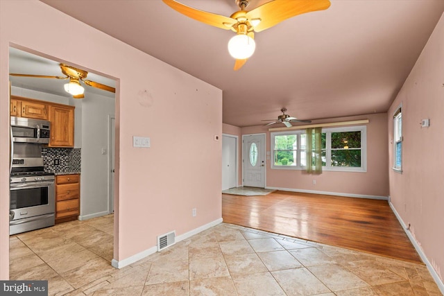 129 Henry Rd, Enola, PA 17025 - kitchen with appliances with stainless steel finishes, a ceiling fan, decorative backsplash, brown cabinetry, and baseboards