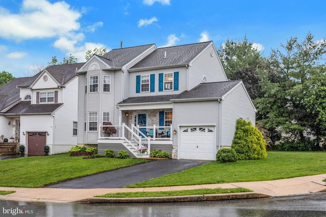 view of front of property featuring covered porch, driveway, a front lawn, and an attached garage