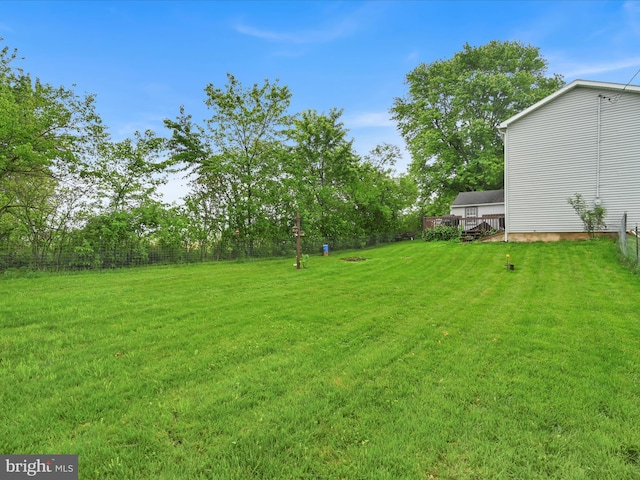 view of green lawn featuring a wooden deck