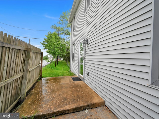 view of property exterior featuring a patio area and fence