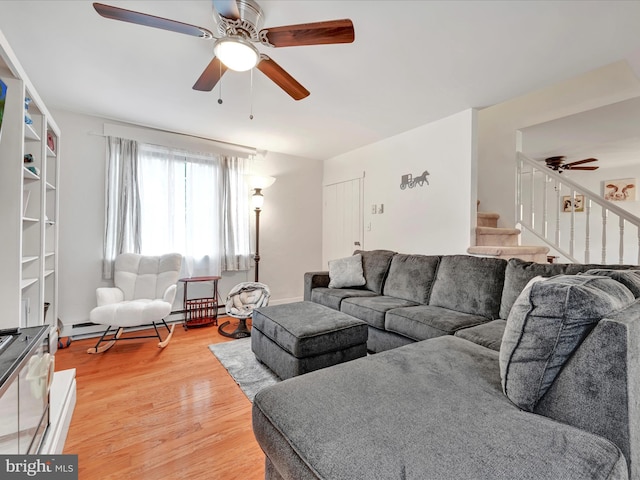 living room with ceiling fan, stairs, and light wood-style floors