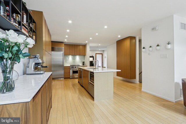 955 N American St, Philadelphia, PA 19123 - kitchen with built in appliances, brown cabinets, modern cabinets, a sink, and an island with sink