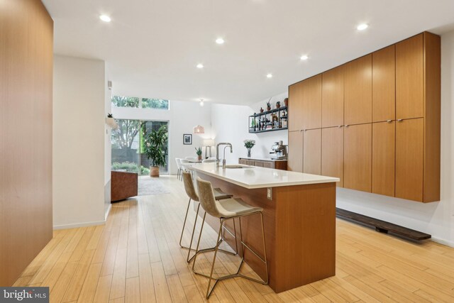 955 N American St, Philadelphia, PA 19123 - kitchen with a sink, light countertops, an island with sink, light wood finished floors, and recessed lighting