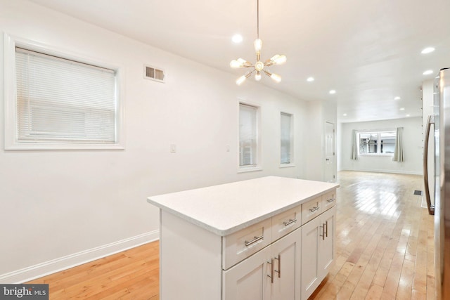 kitchen with a chandelier, light wood-type flooring, a kitchen island, recessed lighting, and decorative light fixtures