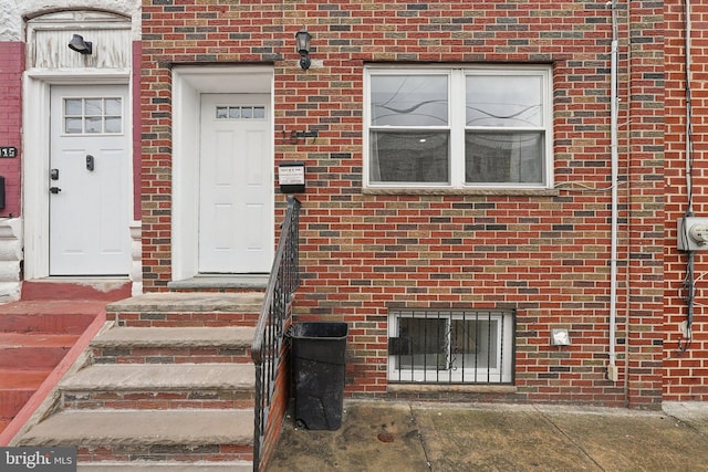 doorway to property featuring brick siding