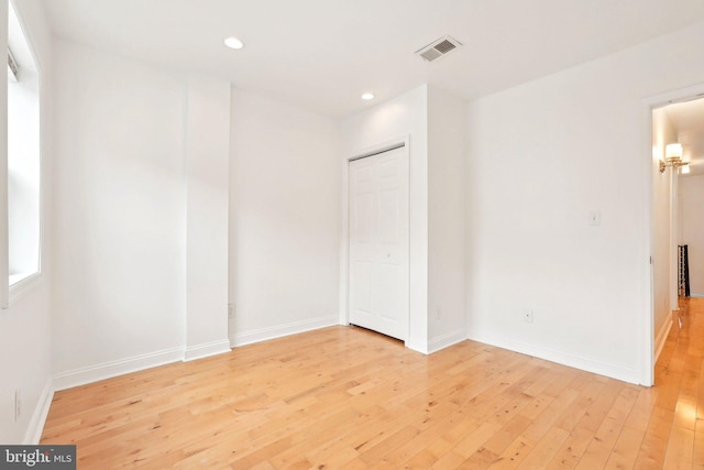 unfurnished bedroom featuring light wood-style floors, recessed lighting, baseboards, and a closet