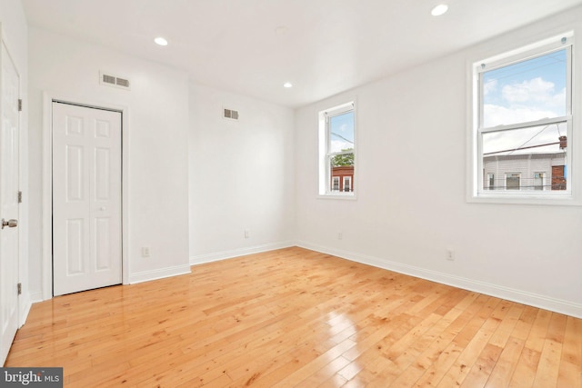 unfurnished room featuring light wood-style floors, baseboards, and recessed lighting