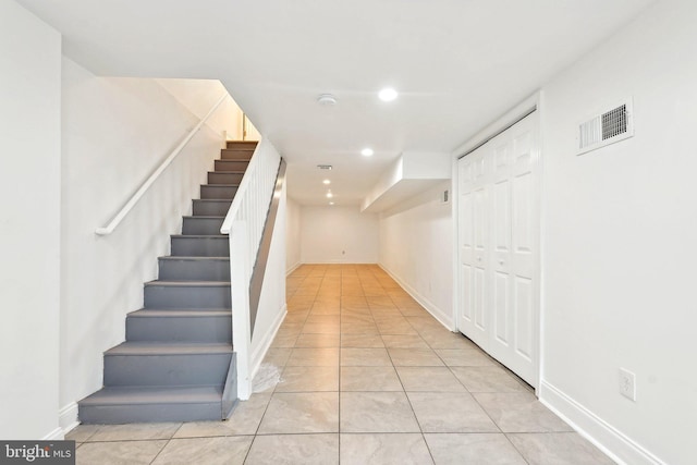 corridor featuring recessed lighting, stairway, light tile patterned floors, and baseboards