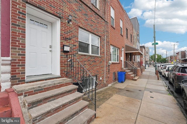 doorway to property featuring brick siding