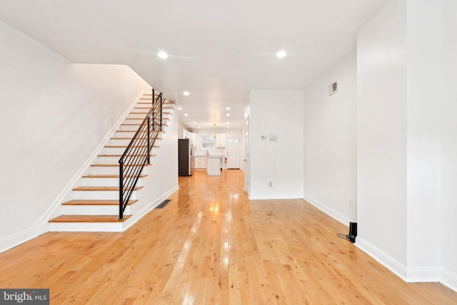 interior space featuring light wood-style floors, stairway, recessed lighting, and baseboards