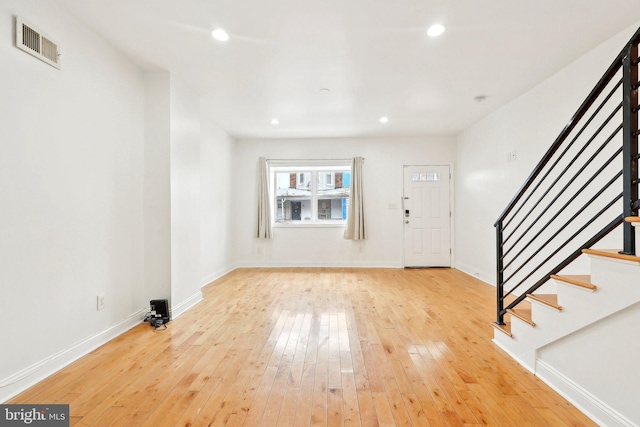 foyer with light wood finished floors, stairs, baseboards, and recessed lighting