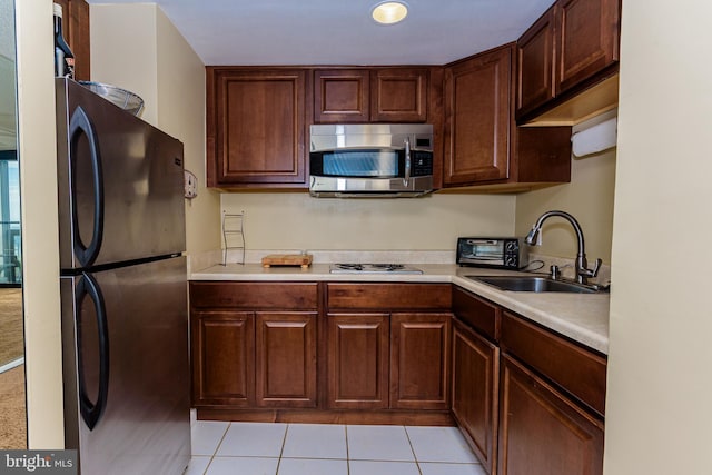 10900 Coastal Hwy Unit 209, Ocean City, MD 21842 - kitchen featuring stainless steel microwave, freestanding refrigerator, a sink, and light countertops