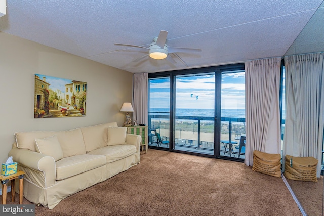 10900 Coastal Hwy Unit 209, Ocean City, MD 21842 - carpeted living room with expansive windows, a ceiling fan, a textured ceiling, and a water view