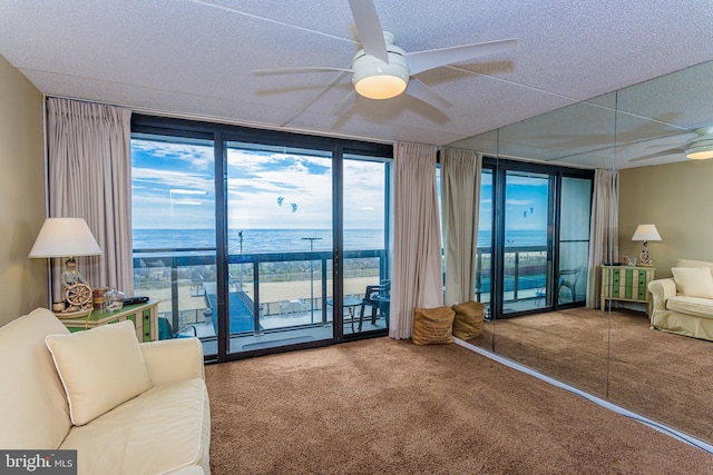 10900 Coastal Hwy Unit 209, Ocean City, MD 21842 - living room featuring floor to ceiling windows, ceiling fan, carpet floors, and a water view
