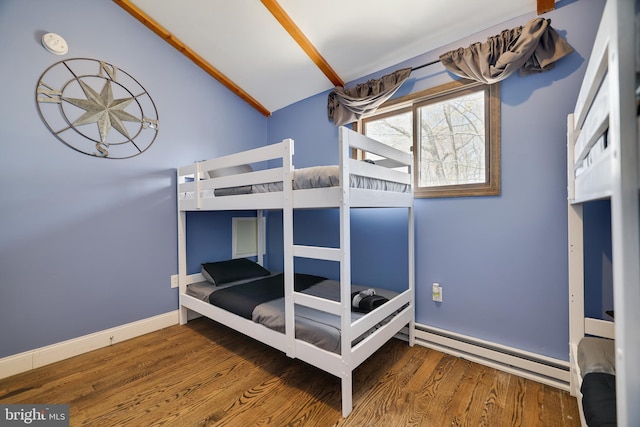 bedroom with vaulted ceiling, baseboard heating, wood finished floors, and baseboards
