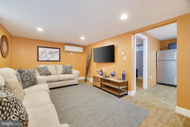 living area featuring an AC wall unit, light wood-type flooring, baseboards, and recessed lighting