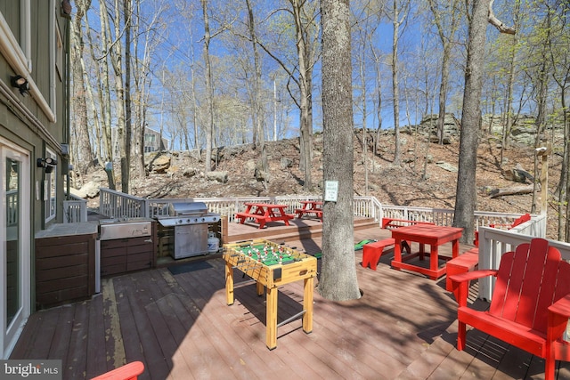 deck with a grill and outdoor dining area