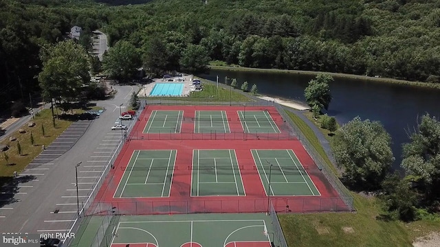 drone / aerial view of a heavily wooded area and a nearby body of water