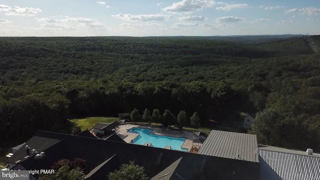 bird's eye view of a heavily wooded area and a pool area