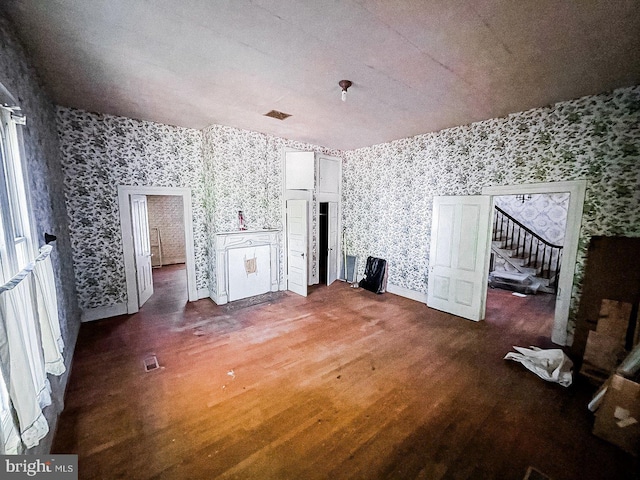 22446E Depot St, Newsoms, VA 23874 - spare room with wallpapered walls, stairs, wood finished floors, and baseboards