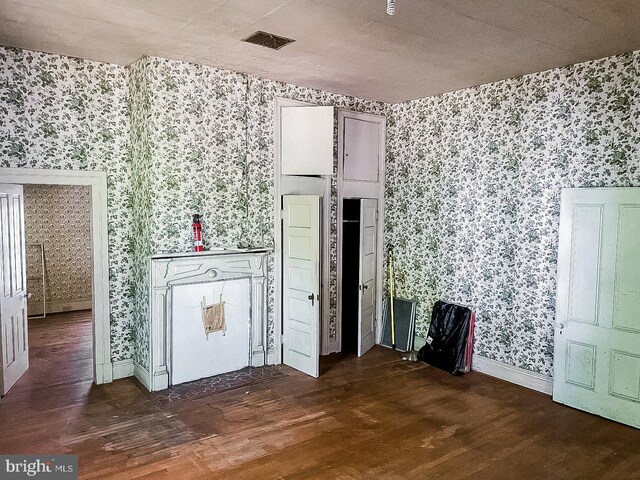 22446E Depot St, Newsoms, VA 23874 - unfurnished room with wallpapered walls, wood finished floors, and baseboards