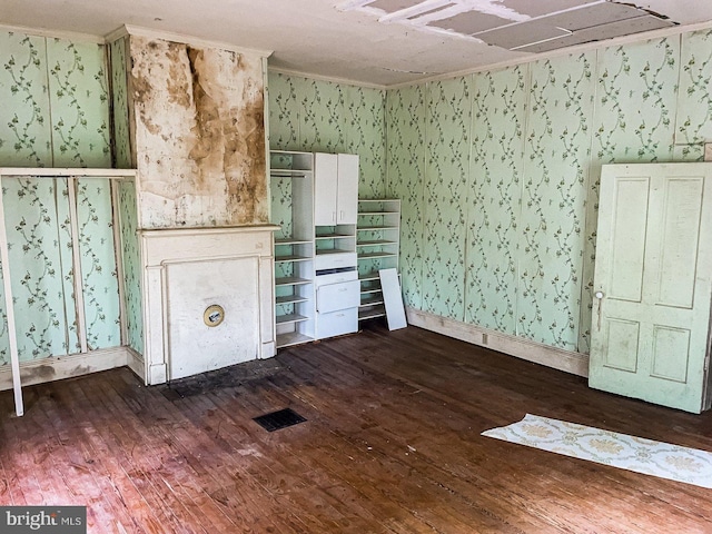 22446E Depot St, Newsoms, VA 23874 - unfurnished living room with wallpapered walls, dark wood-style floors, and baseboards