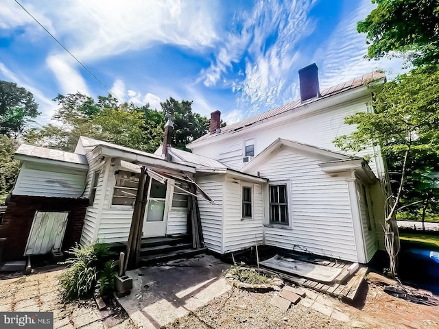 22446E Depot St, Newsoms, VA 23874 - rear view of property featuring a chimney, entry steps, and metal roof