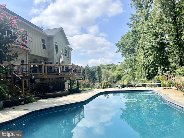 outdoor pool featuring a deck, stairway, and a patio area